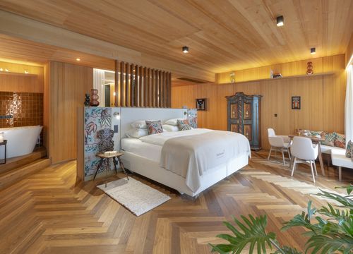 Suite Lavandula in MalisGarten Suite Lavandula mit Doppelbett, Sitzbereich und Holzverkleidung an Wänden und Decke